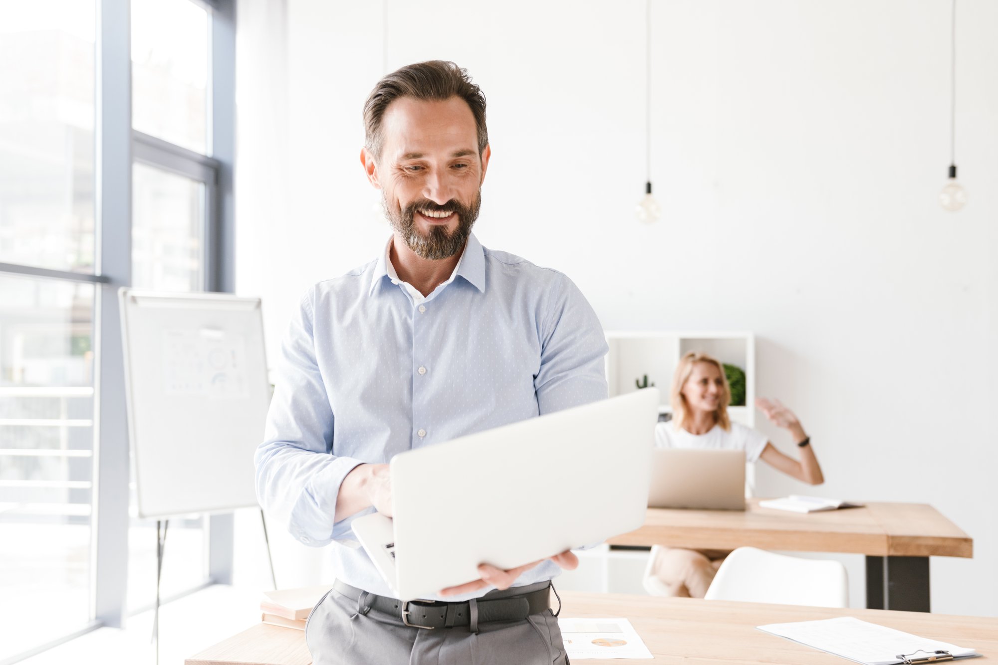 smiling-man-manager-holding-laptop